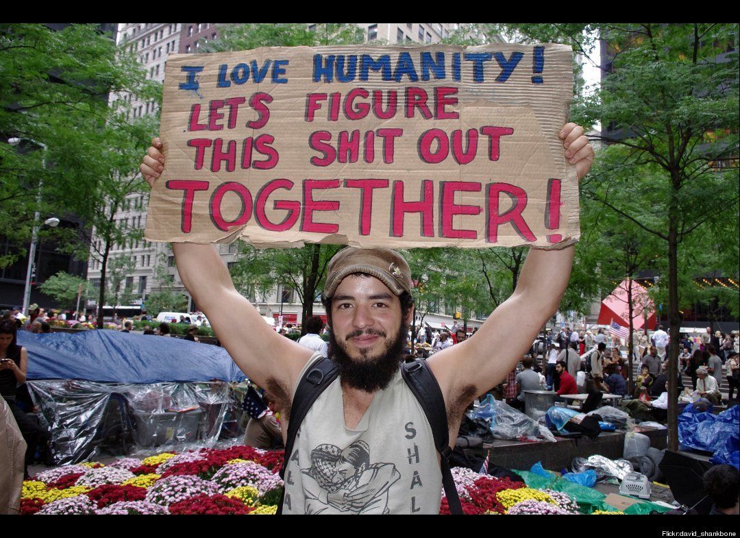 Occupy Wall Street demonstator with sign "I love humanity! Let's figure this shit out together!"
